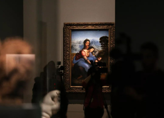 记者在法国巴黎卢浮宫举办的达·芬奇绘画生涯回顾展预展上拍摄，后方是《圣母子与圣安妮》。新华社记者 高静 摄