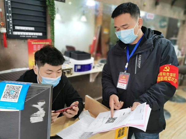 　　彭卫华(右)给社区门店上门宣传防疫知识，赠送防疫资料