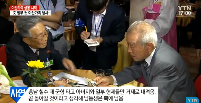 老人将相片摆满桌子，一一给亲人介绍。（韩国YTN电视台）