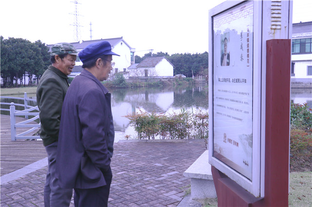  建农村村民在模范宣传屏前驻足观看（中国网记者黄磊/摄）