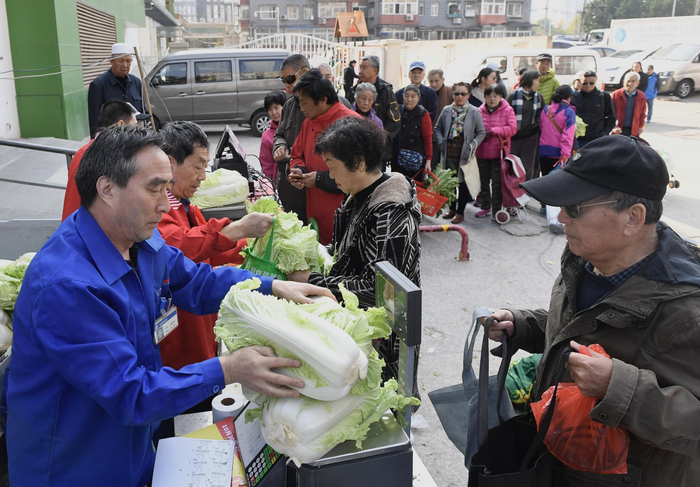 市民在冬储蔬菜销售点前排起长队。摄影/新京报记者 吴宁