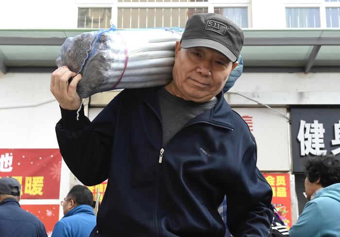 一位老先生购买了一捆冬储大葱。摄影/新京报记者 吴宁
