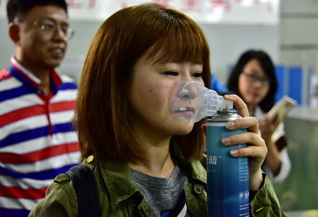 参观者在海南蓝天蓝实业发展有限公司试用罐装空气产品。摄影/章轲