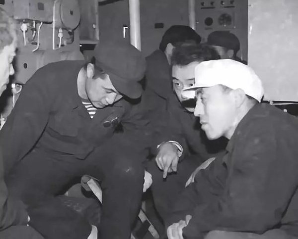 副司令杨玺（左）、见习艇长刘毅（中）检修机械，分析故障。