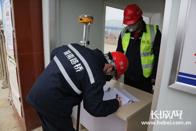 在工地进口检测点，工人正在登记信息。 梁洁 摄