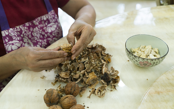 下午没事时，劳拉就会坐在餐桌旁剥核桃。这样等刘欣一家人回来后就能吃到现成剥好的核桃。