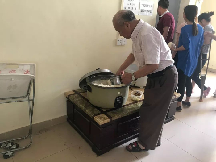 ▲胡厚培在打饭。新京报记者王佳慧&nbsp;摄