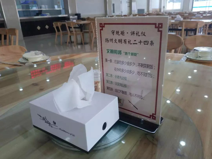 清明节对外开放的扬州市政府食堂，圆桌上一次性消毒餐具、餐巾纸和文明用餐的提示一应俱全。 陈抒怡 摄