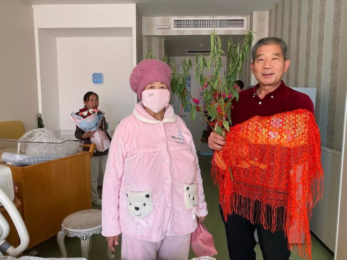 出院前，黄维平手拿桃树枝，与妻子和女儿一起拍照留念。新京报记者&nbsp;祖一飞 摄