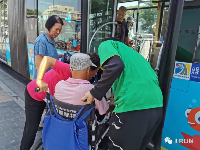  公交车服务人员不知有踏板，乘客帮忙抬轮椅。