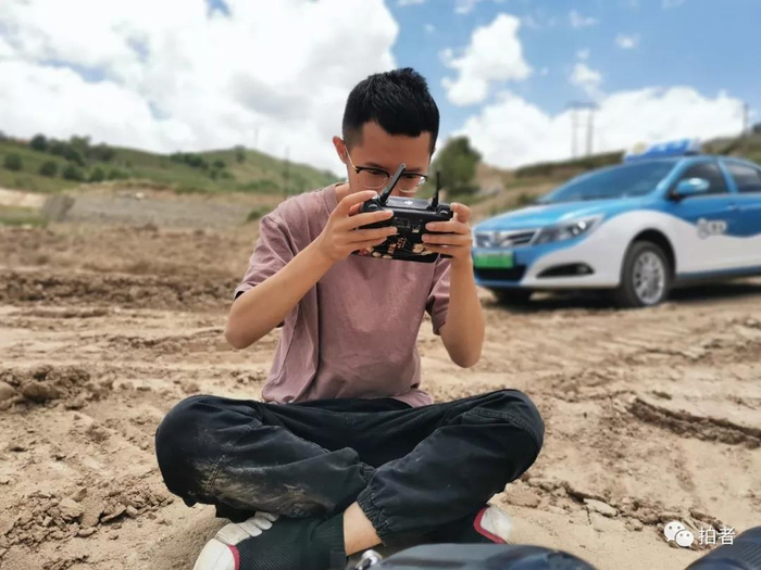  △&nbsp;2019年7月7日，甘肃兰州，新京报记者郑新洽在用无人机拍摄兰渝铁路上的中欧班列。摄影/新京报记者韩茹雪