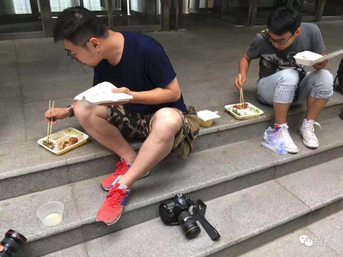  △&nbsp;2016年6月23日，北京，北京青年报记者郝羿和北京日报记者和冠欣边吃饭边等待拍摄高考状元。摄影/新京报记者浦峰