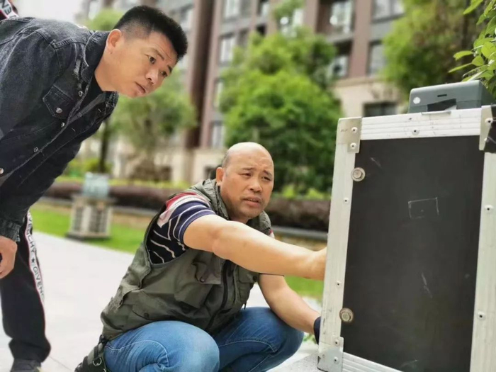 　▲王德瑞（左）在拍摄楼盘宣传片。受访者供图