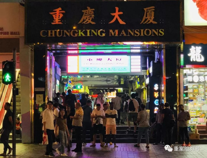 ▲入夜，重庆大厦门口的人们肤色各异。新京报特派香港报道组 摄