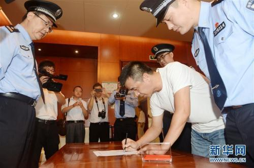 　　资料图：2017年9月25日，在杭州萧山机场，“百名红通人员”徐雪伟在逮捕证上签字。新华社发 张立伟 摄 图片来源：新华网