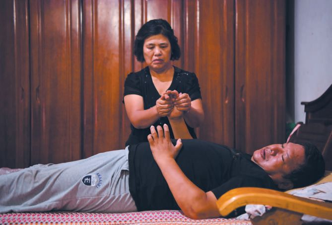 ▲2019年8月16日晚，河北石家庄栾城区西羊市村赵书新家，老伴在给老赵做手部按摩。新京报记者 李木易 摄