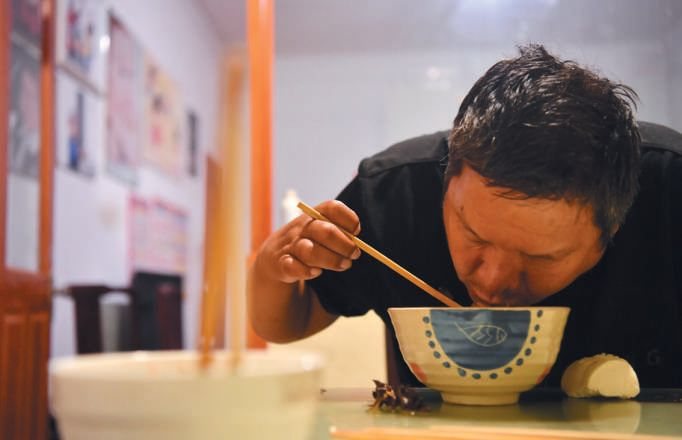 ▲2019年8 月16日晚，河北石家庄栾城区西羊市村赵书新家，赵书新在训练用手指夹着筷子吃饭。新京报记者 李木易 摄&nbsp;