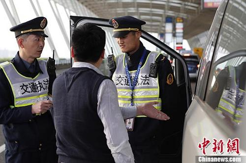 　　资料图：上海加大非法网约车整治力度。图为4月6日执法人员在浦东国际机场对牵涉非法营运车辆进行检查。殷立勤 摄