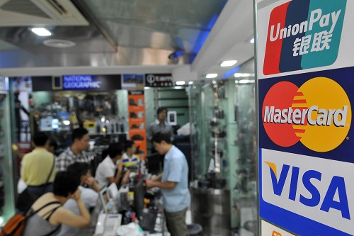 　　2017年4月8日，在美国安阿伯密歇根大学艺术博物馆，密歇根大学艺术史系终身教授包华石（马蒂·鲍尔斯）（前左）与英国伦敦大学亚非学院艺术史教授马啸鸿（沙恩·麦考斯兰）（前右）讨论中国古画《著色山水》（后景玻璃柜中）。 新华社记者王强摄