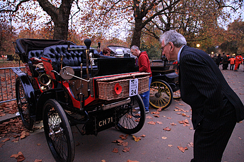  一名老人在伦敦-布莱顿老爷车比赛开始前参观参赛车辆。（新华社）