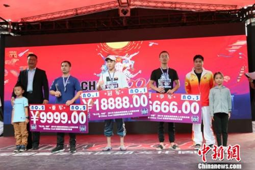 　　国家体育总局社体中心副主任尹国臣（左）和跳水奥运冠军火亮（右二），为获得总决赛前三名的选手颁奖。组委会供图