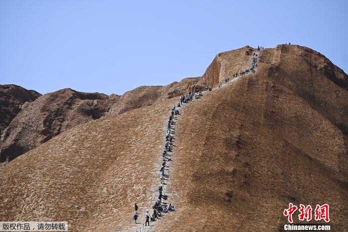  攀登“乌鲁鲁”巨岩的游客排成了长队。