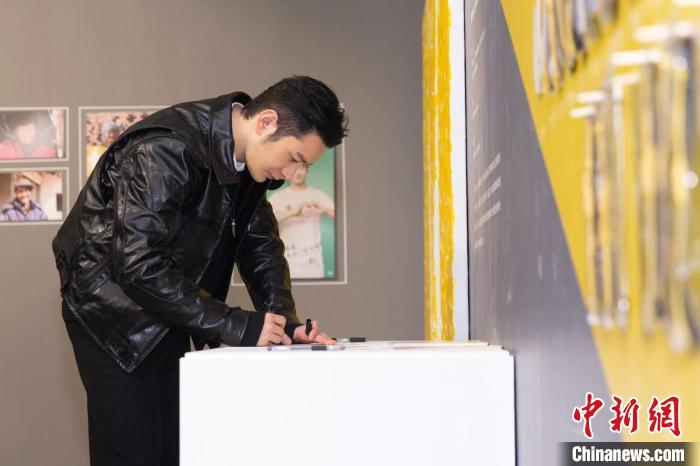 黄晓明填写陪伴老人的承诺卡。