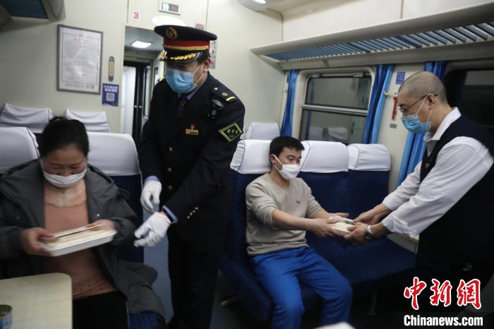 列车工作人员将饭菜“点对点”送至务工人员手中。杨东供图