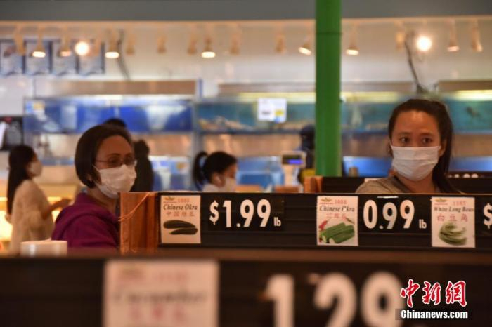 当地时间4月6日，在位于大华府地区的一家超市里，民众普遍佩戴口罩购物。 中新社记者 沙晗汀 摄