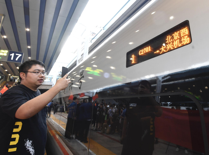 一位乘客在拍照北京西到大兴机场的C2701次列车。摄影/新京报记者 吴宁