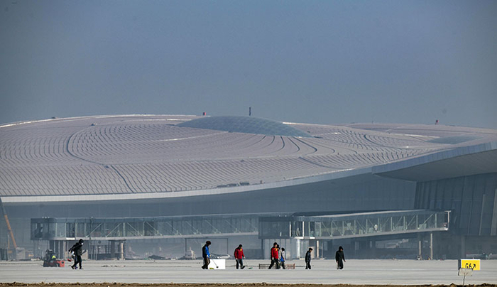 1月21日，为了保证校飞工作的顺利进行。工人们正在加紧对跑道进行清扫和检查。摄影/新京报记者 陶冉