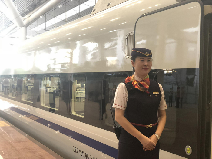 深圳北站，首发列车发车前，乘务员在列车外迎接首批乘客到来。