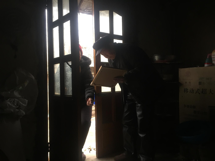 1月5日，李忠山父母在门口借着光找李忠山一家生前的照片，看到孙女李月，李忠山的母亲哭了。&nbsp;&nbsp;&nbsp;&nbsp;新京报记者 赵朋乐 摄