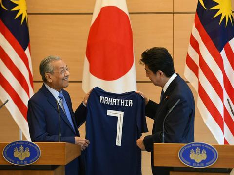  资料图：马来西亚总理马哈蒂尔（左）与日本首相安倍（图源：路透社）