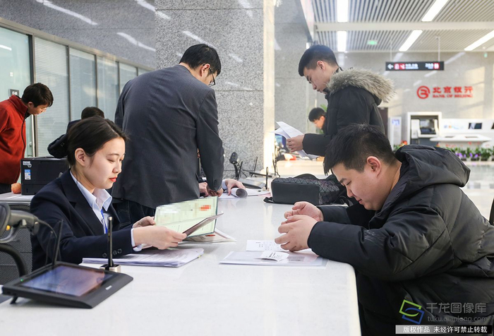 1月2日，北京市政务服务中心开通综合窗口。图为金先生（右一）在综合窗口办事（图片来源：tuku.qianlong.com）。千龙网记者 耿子叶摄