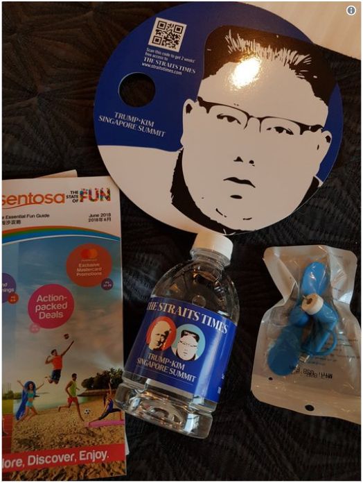 新加坡方面为记者们准备的礼品袋内含一把扇子、一个迷你电风扇、一瓶水和一份旅行指南。