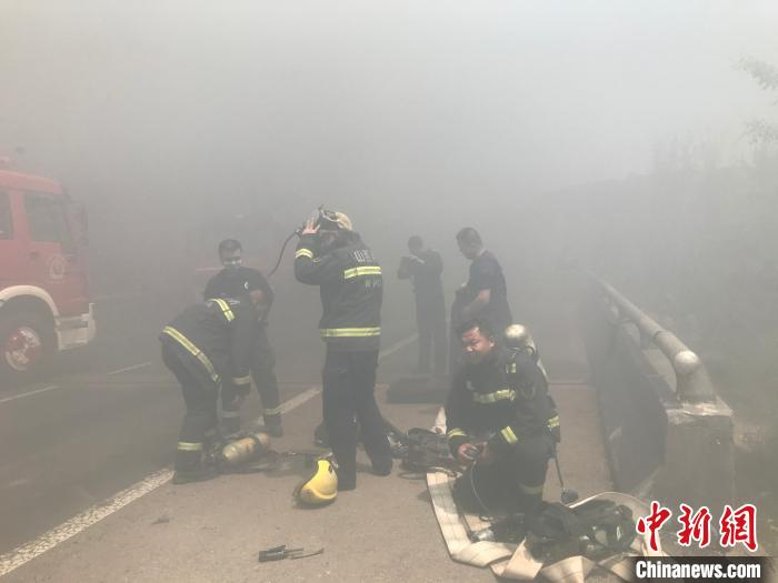 更换防护装备，消防员准备发起二次突击。　周洋 摄