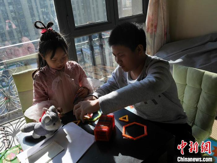 妹妹最喜欢哥哥陪她“搭积木” 苍雁 摄