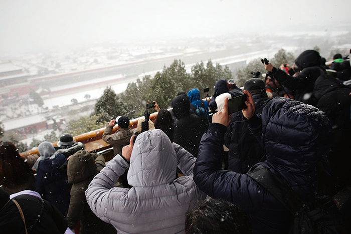 景山万春亭，挤满了观看雪景的游客。