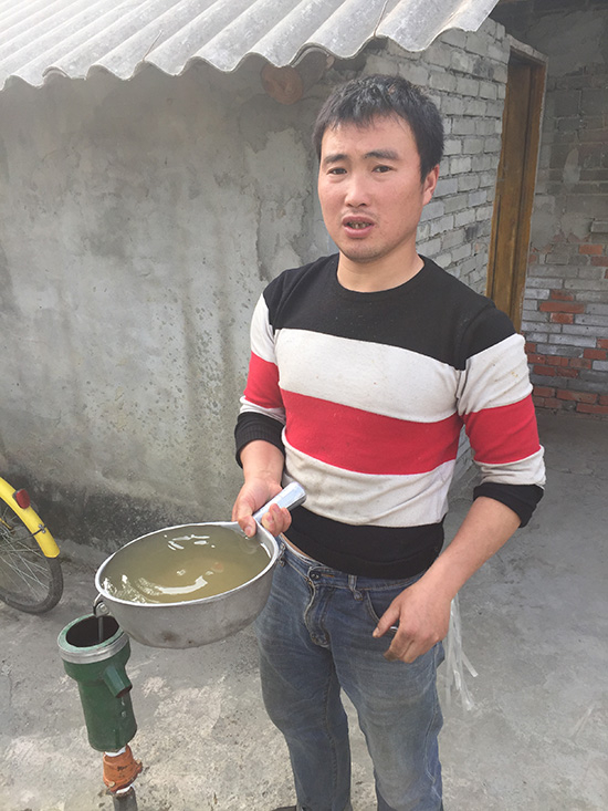 村民们刚打上来的地下水，浑浊且有臭味，无法饮用。赵孟 摄