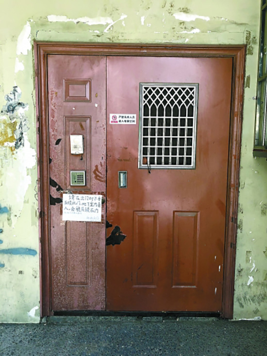 东直门北中街18号楼地下室入口贴着“禁止进入”，但一张白纸上又提示地下室有人。刘桥斌 摄&nbsp;