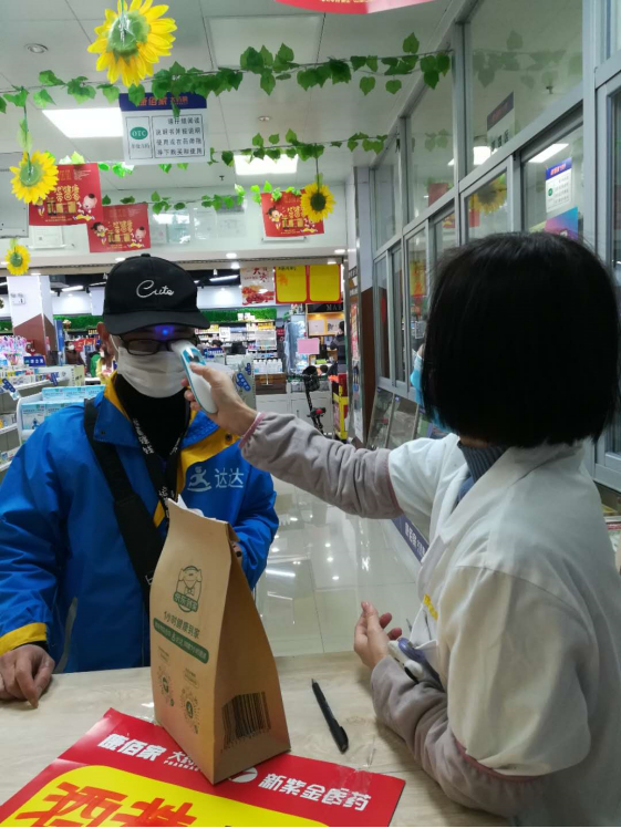 疫情期间达达快送骑士在药店取药时检测体温