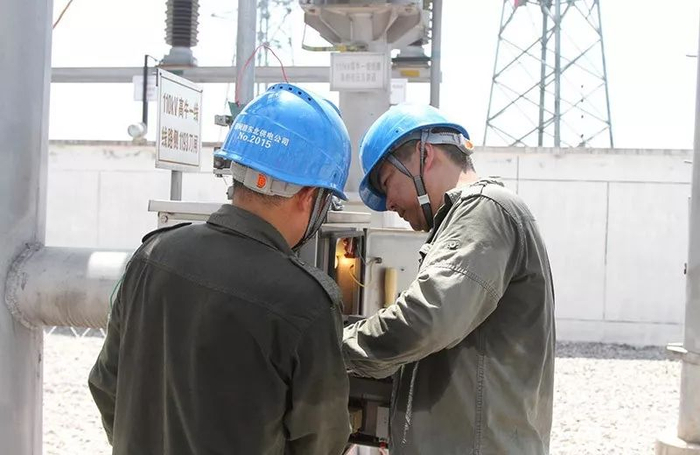 　　▲7月27日，江西赣东北供电公司员工黄坚、彭金刚冒着高温在220千伏高新变电站110千伏高牛一线线路侧1193隔离刀闸操作机构箱调试刀闸。