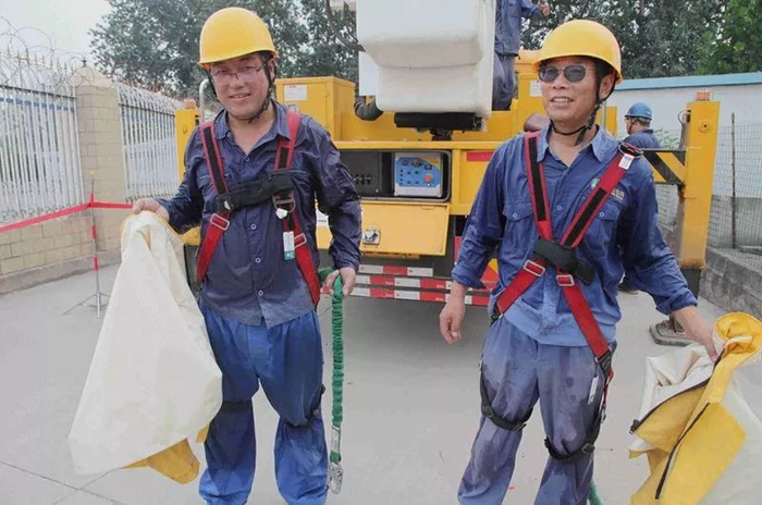 　　▲7月26日，河北石家庄鹿泉区供电公司员工贾建斌、付鹏程完成10千伏西环线莲花山分支6号杆中相隔离道闸上引线更换带电作业后浑身湿透。