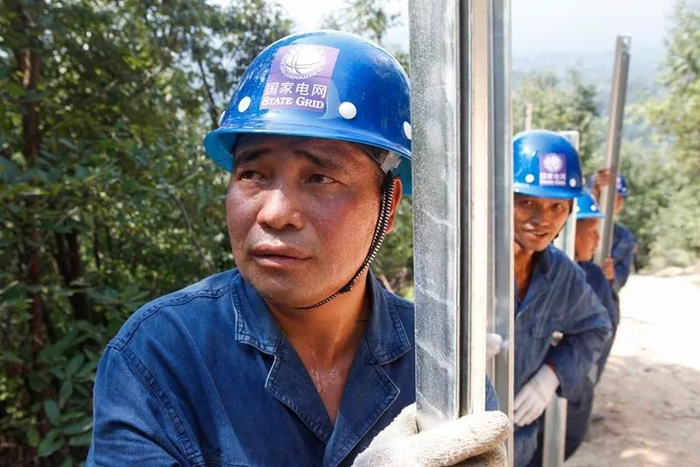 　　▲7月25日，河南平顶山鲁山县供电公司20余名施工人员冒着高温，每人每次扛着40公斤的材料，将3吨铁塔组件搬运至山顶，开展35千伏熊团线43号铁塔组塔施工。