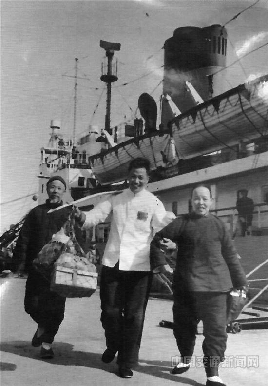 杨怀远靠着一根扁担为需要帮忙的乘客挑行李。特约记者 董翌 翻拍