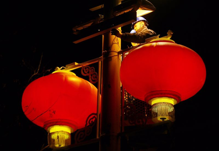 　1月22日凌晨，电力工人在长安街安装春节灯笼。摄影/新京报记者 侯少卿