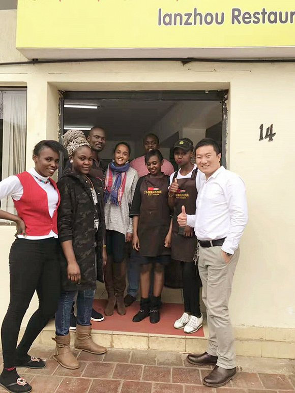 肯尼亚时任总统乌胡鲁•肯雅塔的千金Ngina来面馆就餐，并与工作人员合影。（图中：Ngina 右一：刘勇）