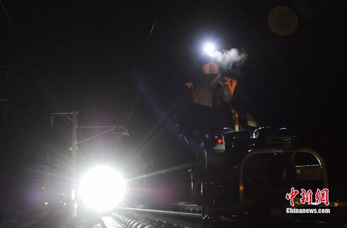 图为高寒缺氧的隧道里，养护工人推着监测小车巡线。 杨艳敏 摄