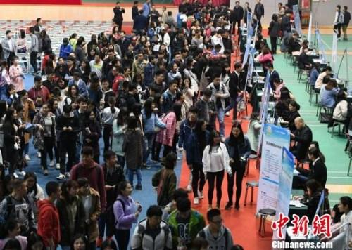 资料图：众多大学生扎堆招聘现场求职。杨华峰 摄